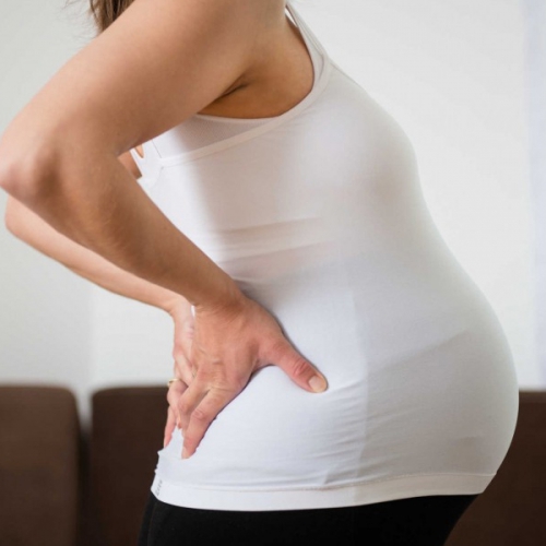 Làm thế nào một tử cung phát triển và phình to có thể chèn ép dây thần kinh gây đau lưng bên trái khi mang thai?
